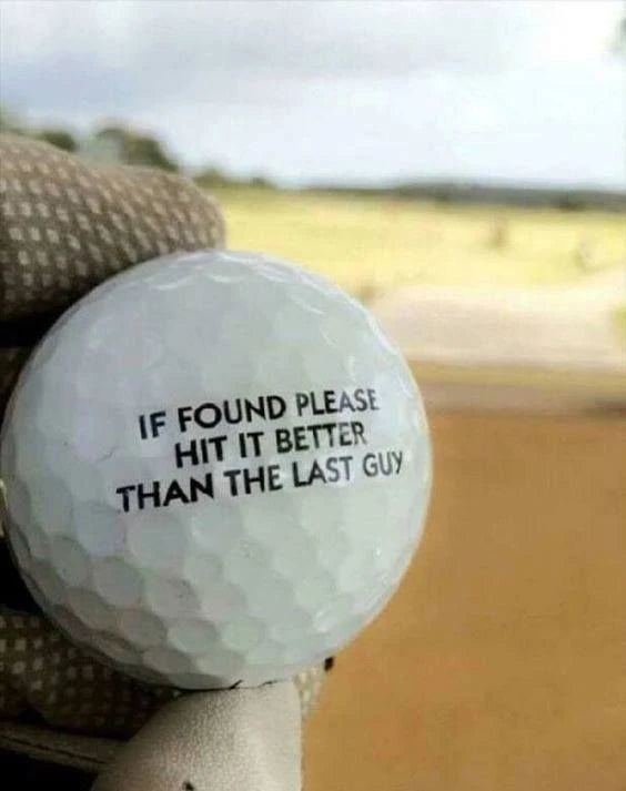 Gloved golfer holding a ball with an If found please hit it better message