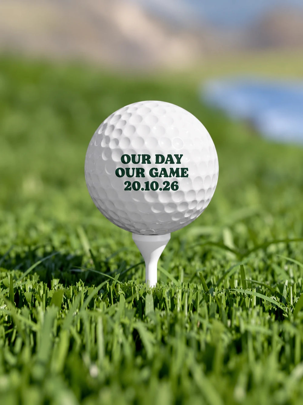 A white golf ball on a tee with a three-line special day message