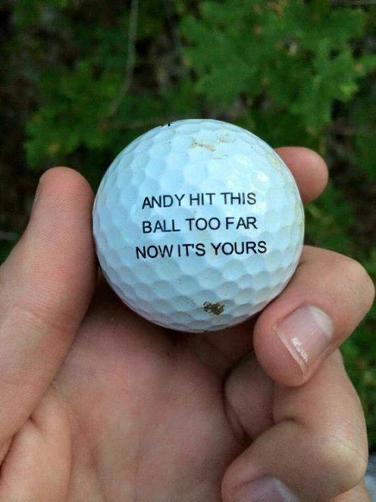 A hand holding a golf ball with a playful message about a long shot