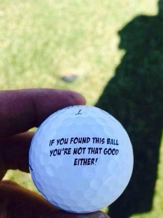 A hand holding a golf ball with a playful found-ball message